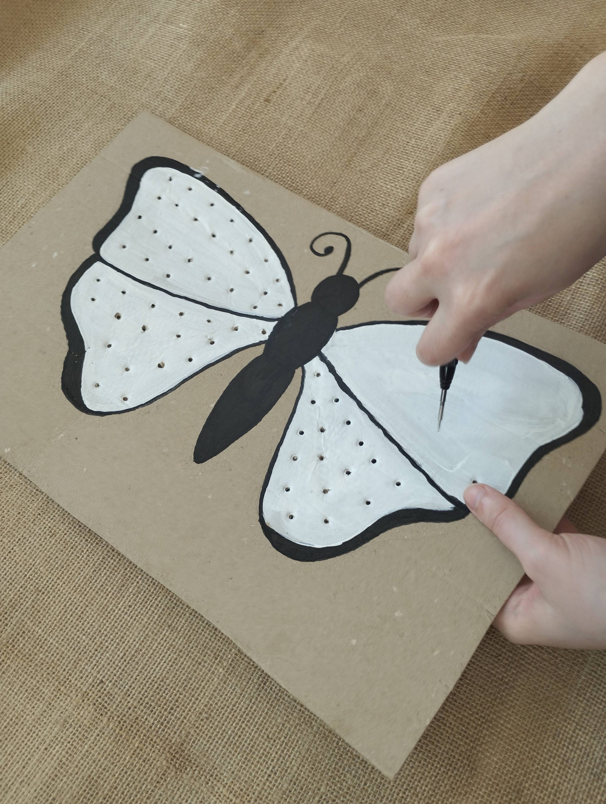Perçage des trous dans les ailes du papillon pour activité motricité fine en maternelle
